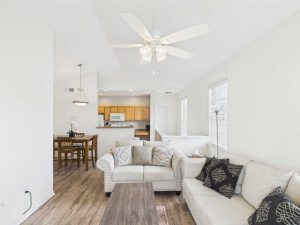 Apartments for rent in Limerick PA USA Bright living room with two beige sofas, a wooden coffee table, ceiling fan, and an open view of the dining area and kitchen in the background.